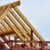 Partially built wooden house frame with exposed beams under a clear sky.